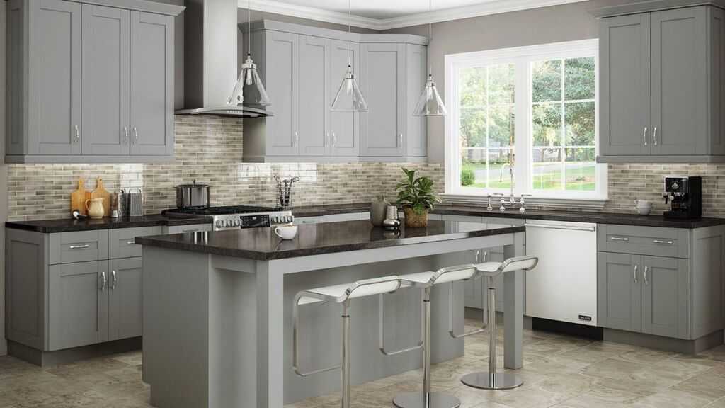 Gray shaker cabinets with dark granite countertops and mosaic tile backsplash